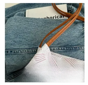 Detail of pink wave pattern fabric bag with premium brown leather strap and stitching
