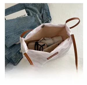 Detail view of pink and white woven tote bag showing spacious storage for daily essentials