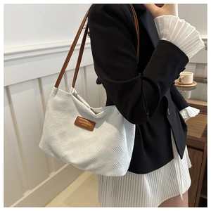 White textured shoulder bag with brown straps styled with a black blazer outfit