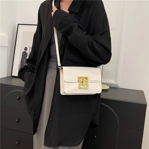 Sac bandoulière blanc brillant pour femme avec boucle dorée géométrique porté par mannequin
