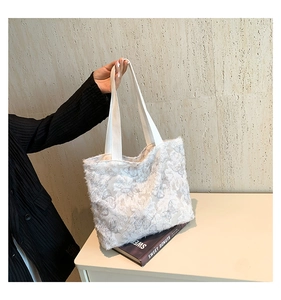 Detailed close-up of white tote bag with textured floral fabric and fabric handles
