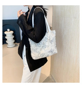 Detail of shoulder tote bag featuring delicate butterfly embroidery and frayed edges