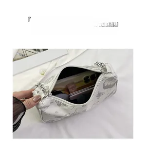 Détail du sac à bandoulière imprimé papillon montrant un intérieur spacieux et pratique