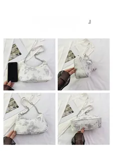 Détails d'un sac demi-lune blanc avec broderies papillons et bandoulière chaîne argent