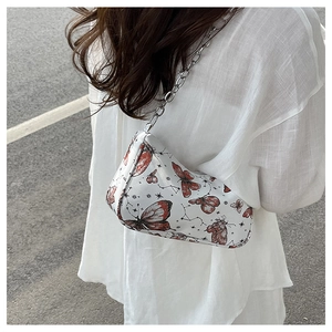 Détail du motif papillon et de la chaîne argentée sur un sac à bandoulière élégant