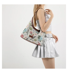 Détail de la broderie florale sur le sac hobo avec bandoulière en cuir et écusson