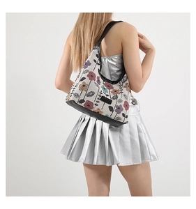 Vue détaillée du sac brodé de fleurs avec bandoulière en cuir noir sur un mannequin