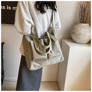 Detail of grey-green large capacity tote bag with large 3D pockets and wide straps