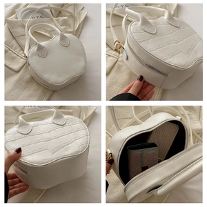 Macro view of white heart-shaped handbag showing stone texture and interior capacity