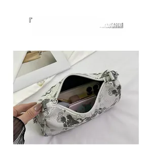 Detail view of white canvas cylinder bag showing internal storage for phone and makeup