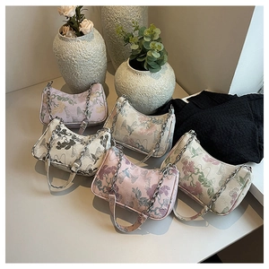 Detail of embroidered floral patterns and metal chain on diverse woven tote bags