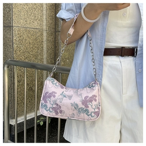 Detail of pink floral embroidery and silver chain on a modern Chinese style baguette bag