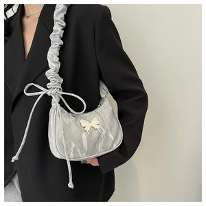 Dettaglio borsa hobo argento increspata con fibbia a farfalla e tracolla arricciata