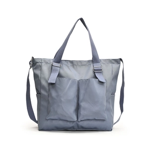 Minimalist grey-blue large tote bag with dual front pockets and adjustable shoulder strap