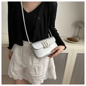 Silver minimalist shoulder bag with metallic finish and metal logo on a model