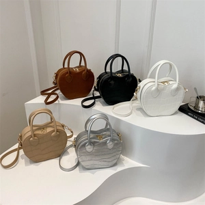 Chic croc-embossed heart-shaped handbags in five versatile colors on a display stand
