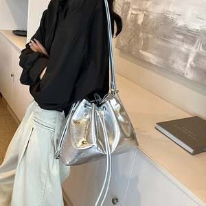 Moderner silberner Metallic-Beutel mit Kordelzug am Model in stilvollem Interieur