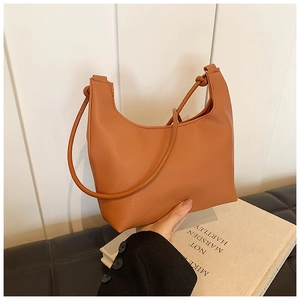 Détail du sac en similicuir orange-marron à texture litchi avec anse à nœud design