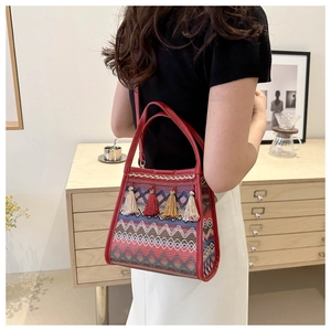 Dettaglio borsa a secchiello etnica con trama ondulata colorata e nappe decorative
