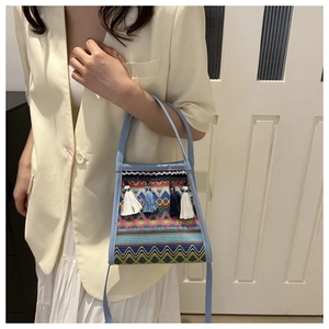 Dettaglio della borsa a secchiello boho con motivi geometrici e nappe colorate