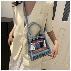 Dettaglio borsa a secchiello etnica intrecciata con motivi colorati e nappe pendenti