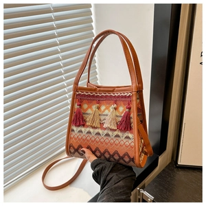 Dettaglio della borsa a secchiello bohémien con nappe colorate e motivi intrecciati