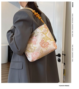 Detail of floral embroidery on silk satin tote with unique wooden bead shoulder strap