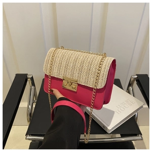 Detail of pink leather and beige straw patchwork crossbody bag with gold metal chain