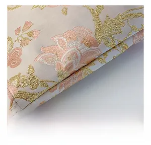 Detail of premium jacquard fabric with pink flower petals and golden silk embroidery