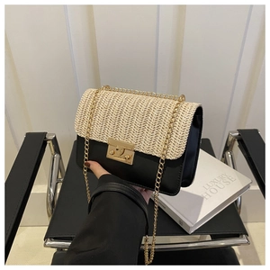 Detail of hand-held straw flap shoulder bag with gold chain and metal lock closure