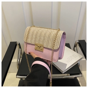 Detail of pink faux leather and straw woven crossbody bag with gold chain strap