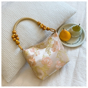 Detail of floral embroidery and wooden bead handle on vintage crossbody tote bag