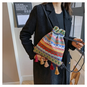 Dettaglio della borsa a secchiello boho con trama geometrica colorata e nappe a frangia