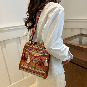 Detail of bohemian woven crossbody bag featuring colorful geometric patterns and long tassels
