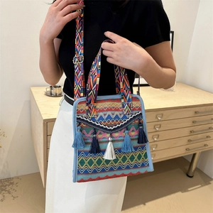 Detail of bohemian woven crossbody bag with colorful zigzag patterns and hanging tassels