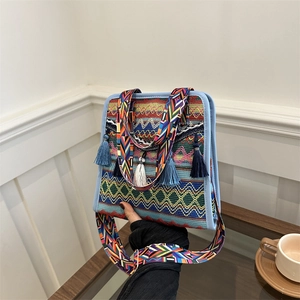 Detail of bohemian woven crossbody bag with colorful geometric patterns and blue tassels