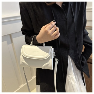Detail der weißen Lederhandtasche mit Klappenverschluss und Fashion & Bag Prägelogo