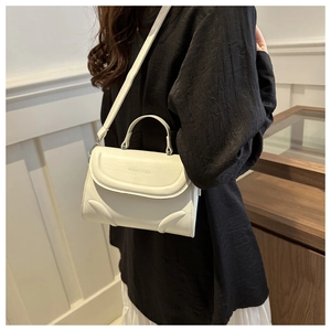 Chic cream leather handbag with Fashion & Bag embossing worn by a model as a crossbody bag