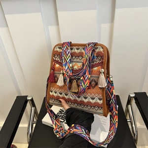 Detail of ethnic jacquard shoulder bag with tassels and colorful woven strap