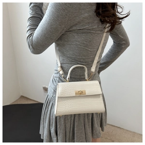 Gros plan du mini sac blanc effet croco avec fermoir doré et bandoulière réglable