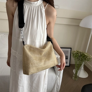 Large woven tote bag with wide black shoulder strap and silver chain details for summer