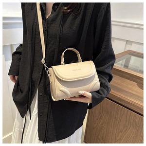 Close-up of beige handbag with wavy texture and Fashion & Bag embossed lettering