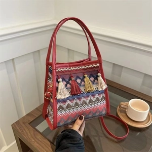 Borsa a secchiello etnica tessuta con motivi geometrici colorati e nappe con frange