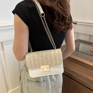Fashionable straw woven crossbody bag with gold chain strap and elegant contrast panels