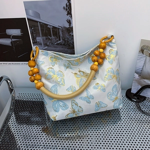 Beige butterfly embroidery tote bag with woven rope handle and yellow wooden beads detail