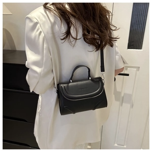 Detail of black crossbody bag with Fashion & Bag embossing and silver metal clips