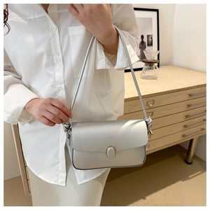 Gros plan sur un sac à bandoulière argenté avec boucle ovale et détail de nœud élégant