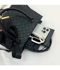 Détail du sac cabas tressé noir avec nœud montrant sa grande capacité de rangement intérieur