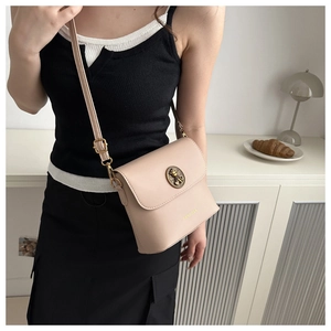 Vue détaillée du sac bandoulière rose avec une boucle en métal ornée d'un ourson