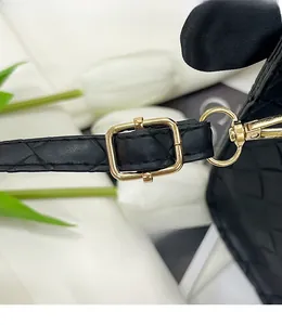 Détail de la bandoulière en cuir noir matelassé avec boucle dorée et crochet à ressort